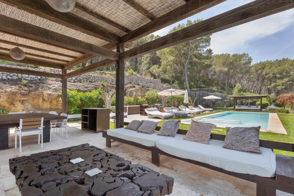 an outdoor patio with a couch and a pool at Can Ribes Ibiza in Illes Balears
