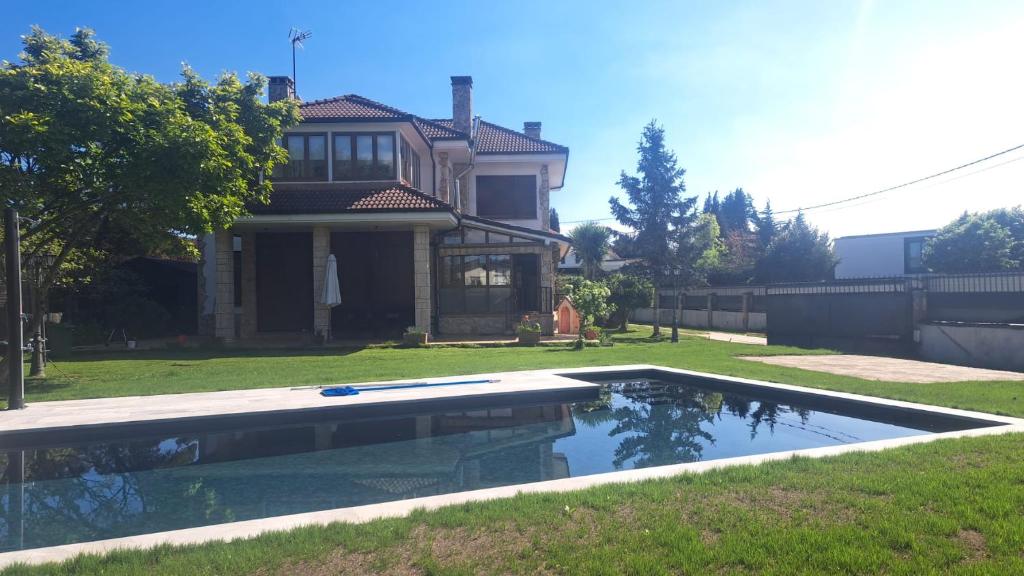 a swimming pool in the yard of a house at Casa Chalet, Villa Elisa in Gijón