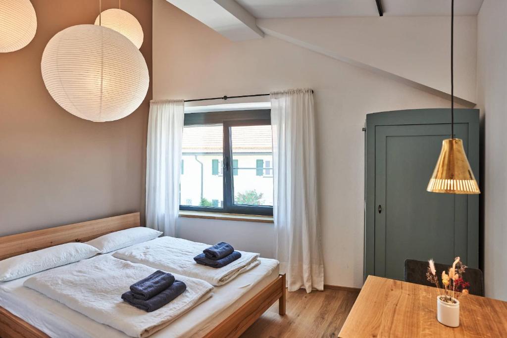 a bedroom with a bed and a table and a window at Alte Seifensiederei - Cisco in Bad Tölz