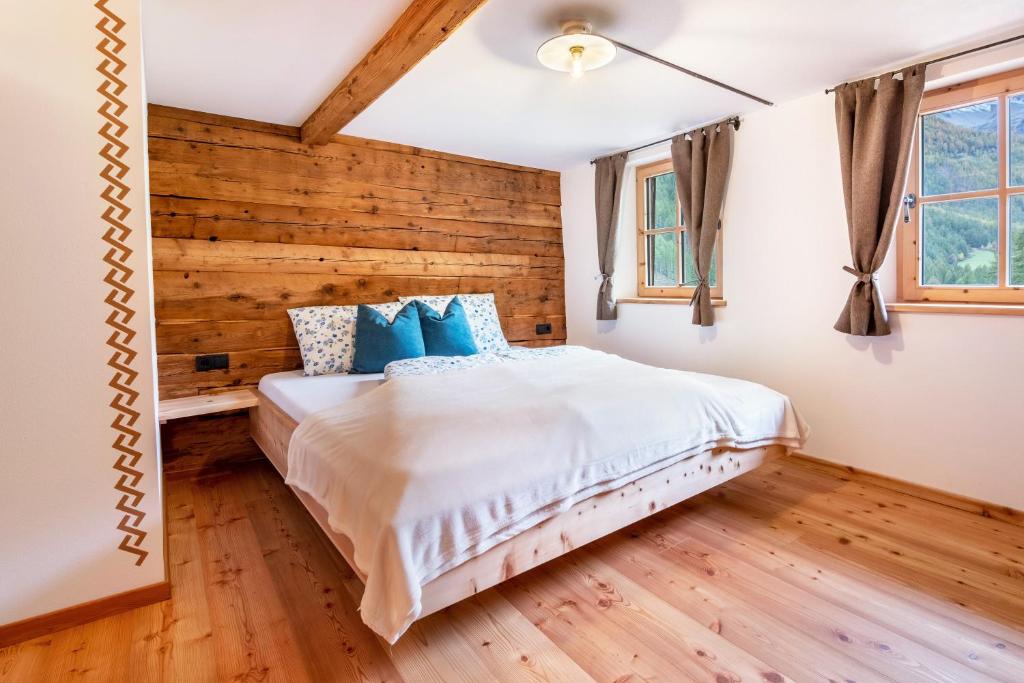 a bedroom with a wooden accent wall and a bed at Innerforchhof Schnals in Madonna