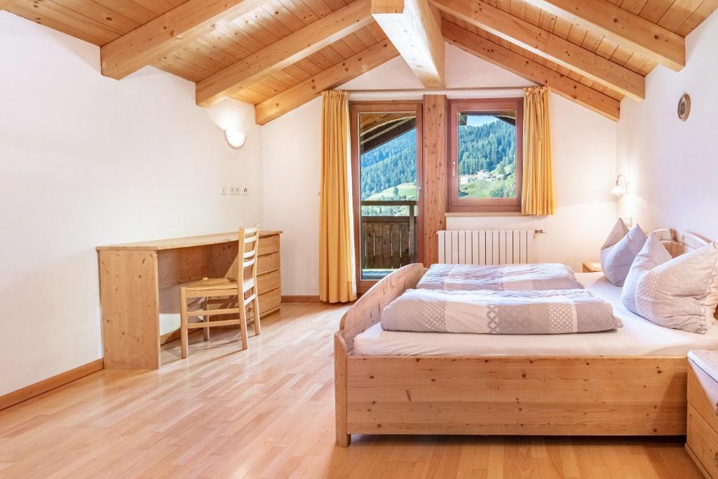 a bedroom with a bed and a desk at Mansardenwohnung Egart in Resia