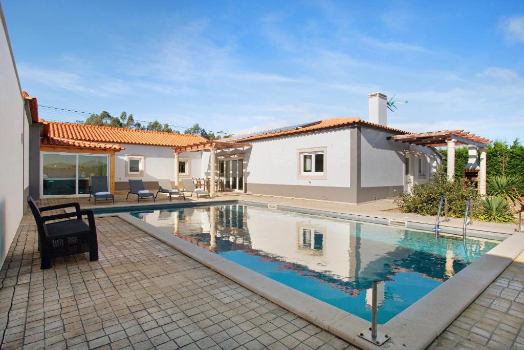 a swimming pool in the backyard of a house at Villa Rosa com Piscina e Jacuzzi in Salir de Matos