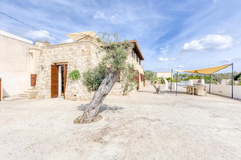 a tree in front of a building with a building at Villa Liscedde Leuca in Castrignano del Capo
