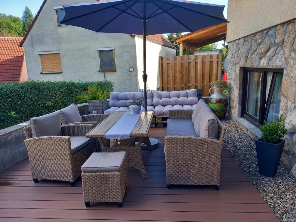 a patio with a table and chairs and an umbrella at Ferienwohnung Reblaus in Markt Einersheim