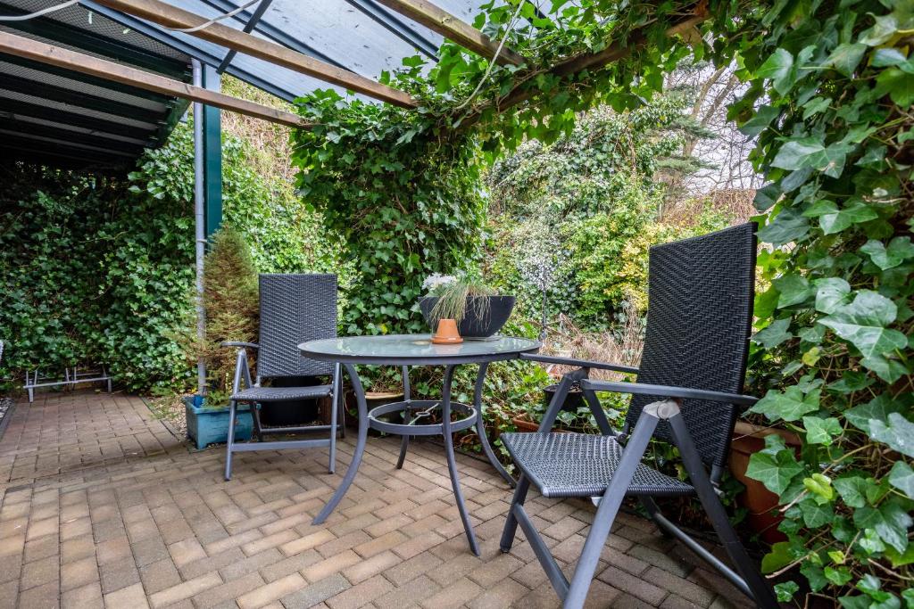 a patio with two chairs and a table in a garden at Ferienwohnung Mit Maritimen Flair in Lohme