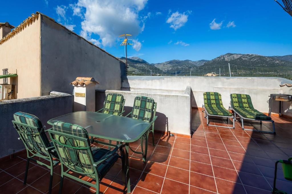 a patio with a table and chairs on a roof at Duplex Can Roses in Moscari