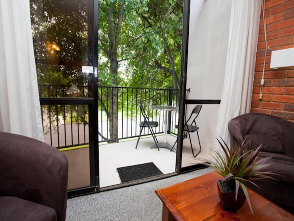 a living room with a sliding glass door to a balcony at Connells Motel & Serviced Apartments in Traralgon