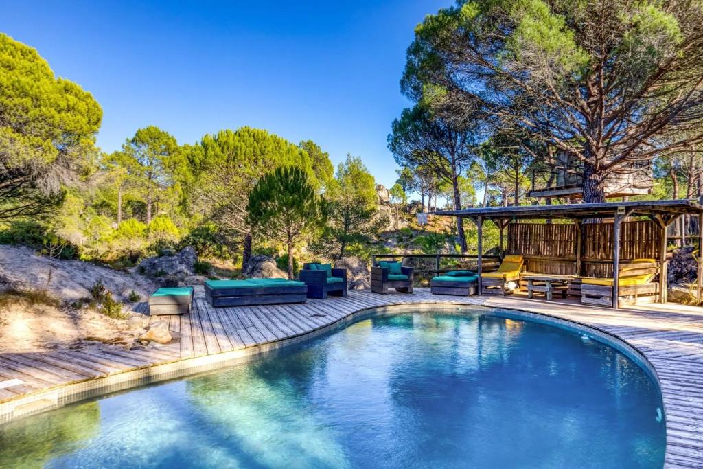 a swimming pool with a patio and a house at Le Sabel - Cabanon in Mourèze