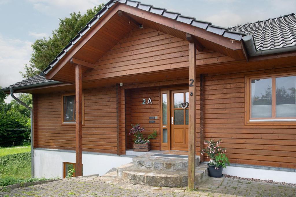 a wooden house with a door and a porch at Entenhaus in Hilgendorf