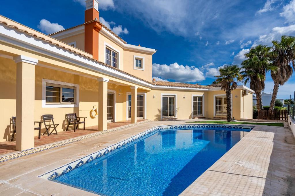a villa with a swimming pool and a house at Villa Alvor in Alvor