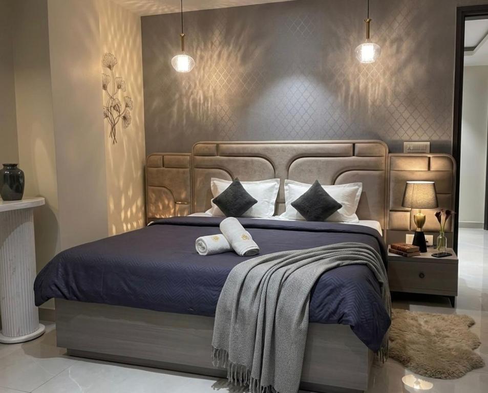 a bedroom with a large bed with blue sheets and pillows at The Bloomhouse inn in Rājpur