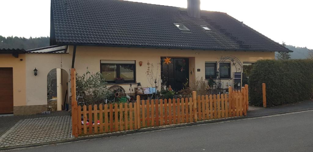 a house with a wooden fence in front of it at Ferienwohnung Karin in Eltmann