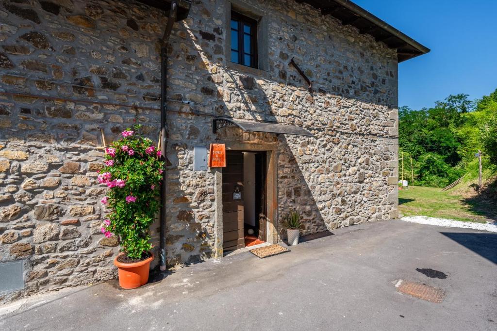a stone building with flowers in front of it at Casale di Polly in Garfagnana in Minucciano