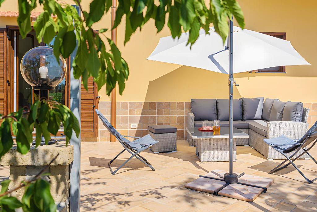 a patio with a couch and chairs and an umbrella at Casa Vacanza Anni' in Vico Equense