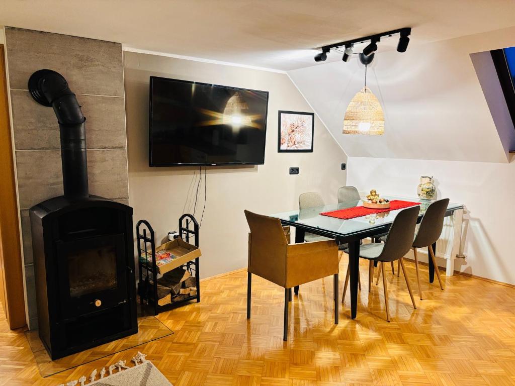 a dining room with a fireplace and a table with chairs at Mmapartment in Feistritz ob Bleiburg