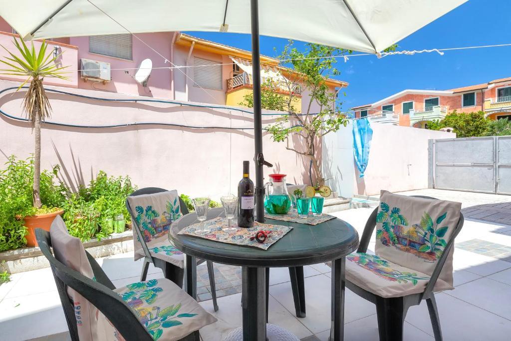 a table with two chairs and a bottle of wine at Casa Loretta 3 in Valledoria