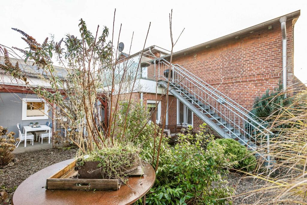 a brick building with a spiral staircase in a garden at Ferienwohnung Doris in Viöl