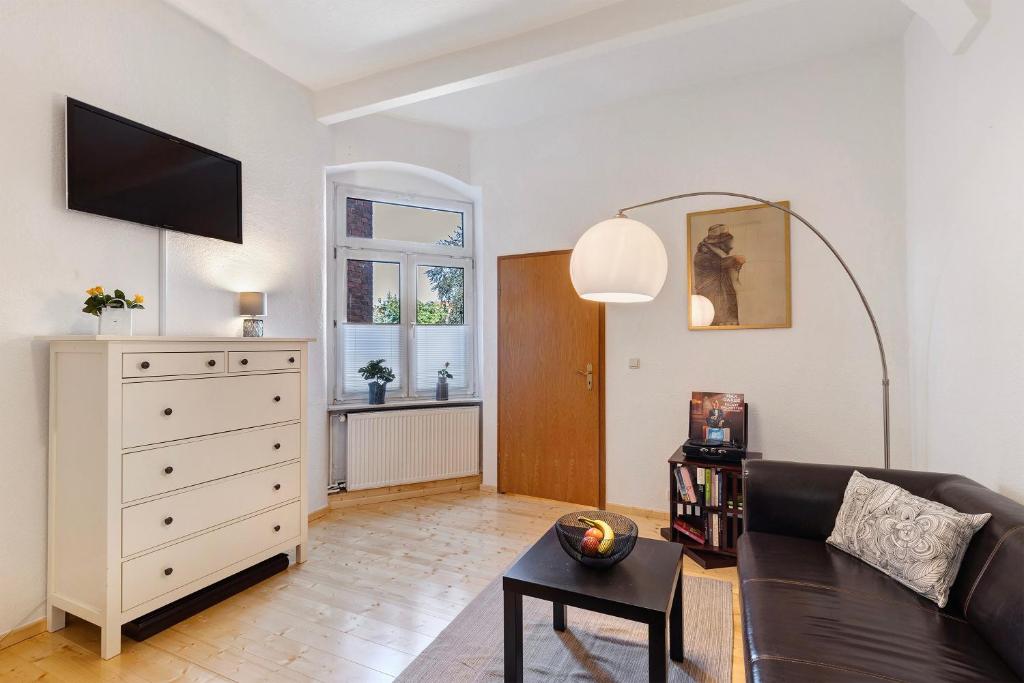 a living room with a couch and a dresser at Apartment City Leben in Nordhausen