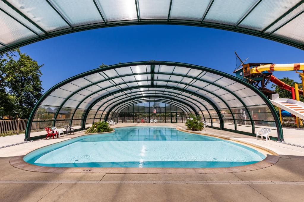 a large swimming pool in a building with a tunnel at Chalet Yoya in Lanton