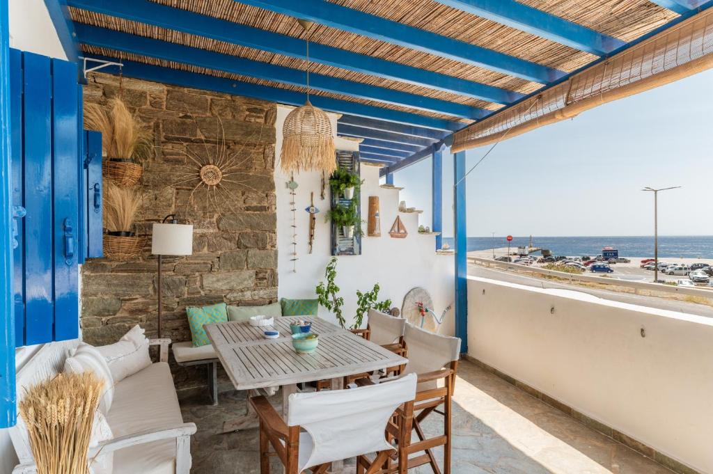 a patio with a table and chairs and the ocean at Waterfront Masterpiece in Tinos