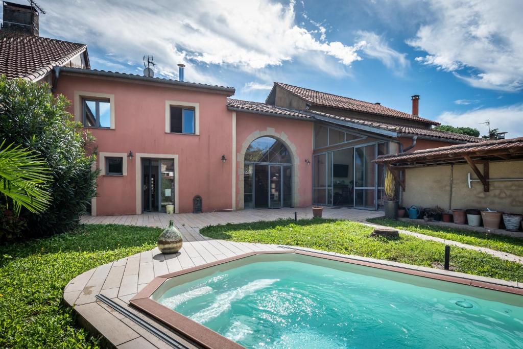a swimming pool in front of a house at Maison avec piscine in Marciac