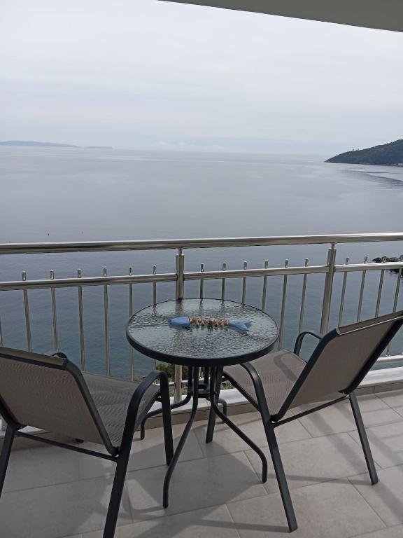 a table and chairs on a balcony with the ocean at Tigani House in Tyros