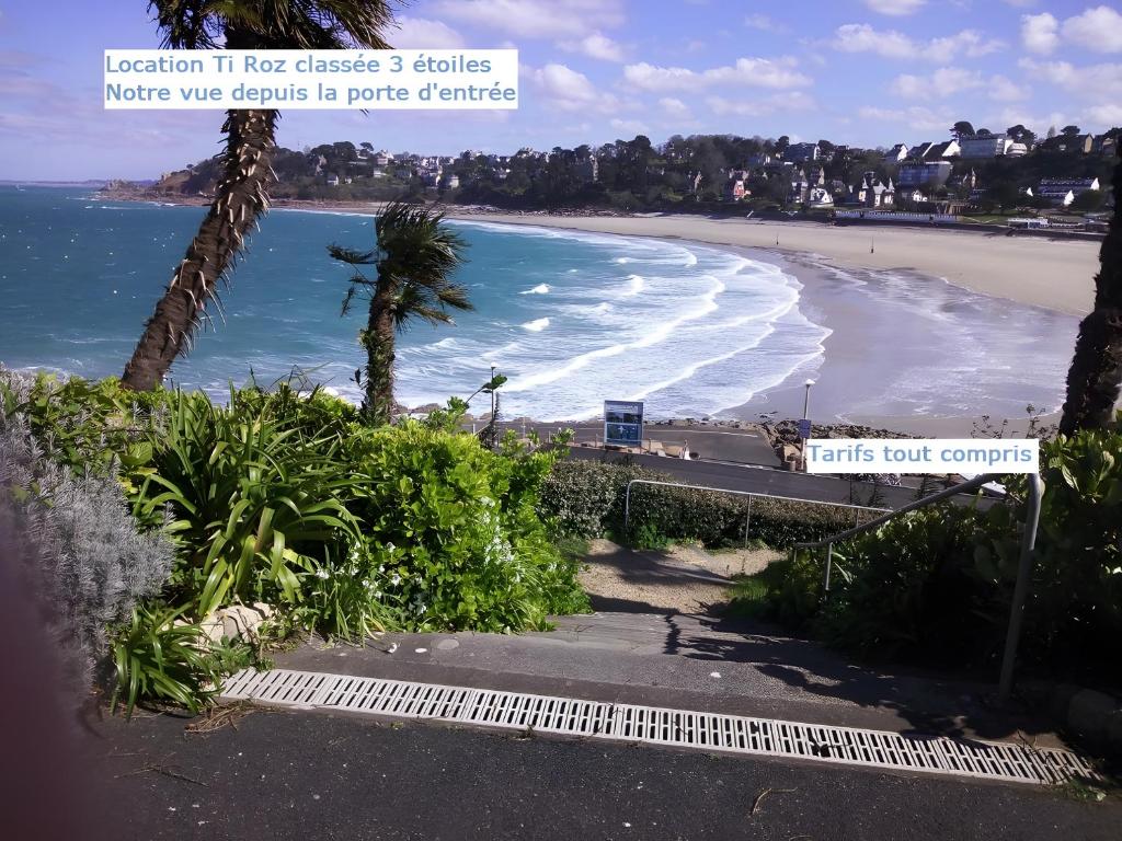 a view of a beach with palm trees and the ocean at Ti Roz - Vue mer in Perros-Guirec