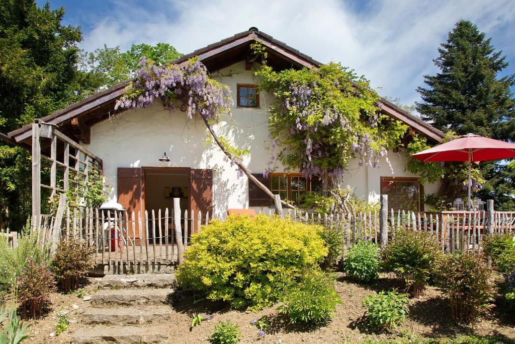 a white house with a fence and an umbrella at Ferienhaus Auszeithaus in Zell