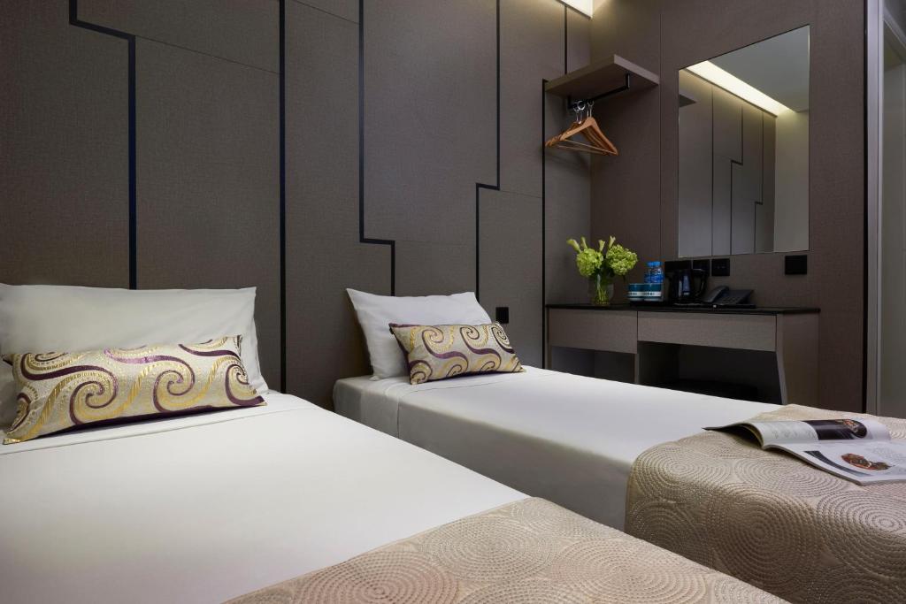 um quarto com duas camas e uma mesa com um espelho em Hotel 81 Gold em Singapura