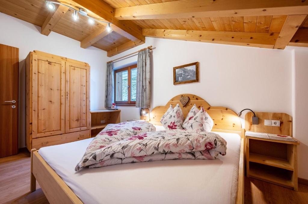 a bedroom with a large bed with a wooden headboard at Raffreiderhof Apt Fichte in Luson