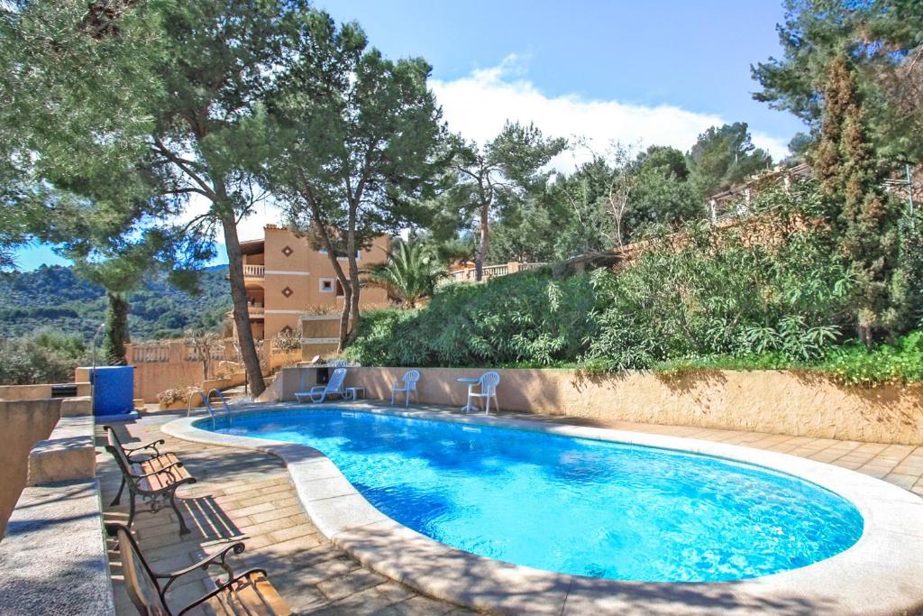 a swimming pool with chairs next to at Montemar 34 in Port de Soller