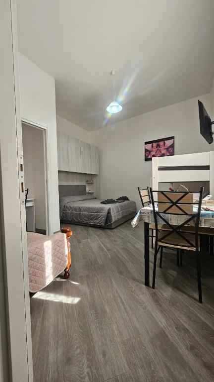 a room with a bed and a table and chairs at Casa Andrea in Assemini