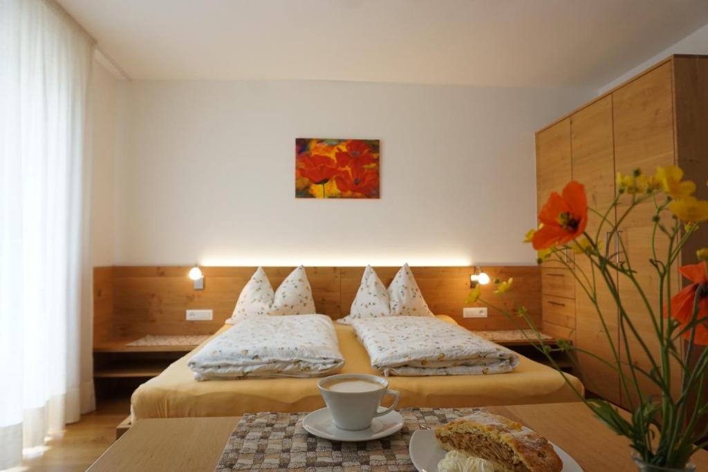 a hotel room with two beds and a table at Waalhof Ferienwohnung Mohnblume in Silandro