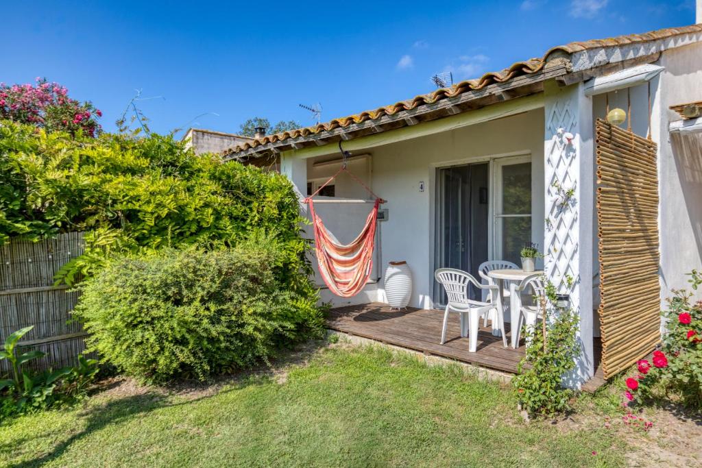 a patio with a table and chairs on a porch at Mas des Cypres - Mazet 4 in Saintes-Maries-de-la-Mer