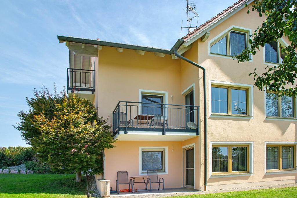 a large yellow house with a balcony at Ferienwohnungen Hackerhof in Bad Füssing