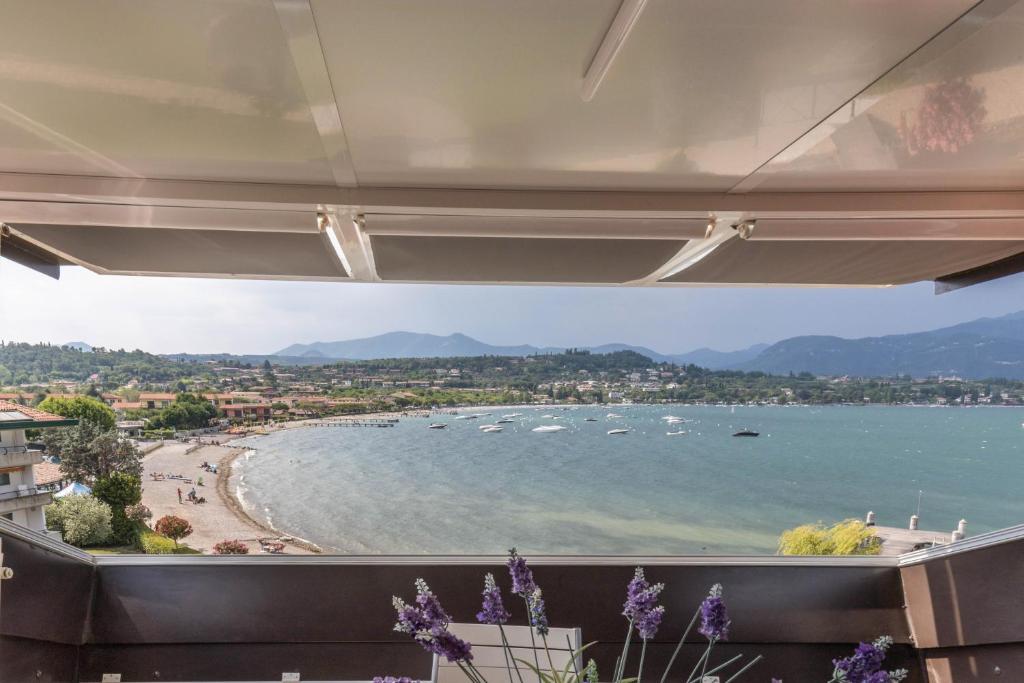 a view of a beach with boats in the water at Residence Gigi Complex Manerba in Manerba del Garda