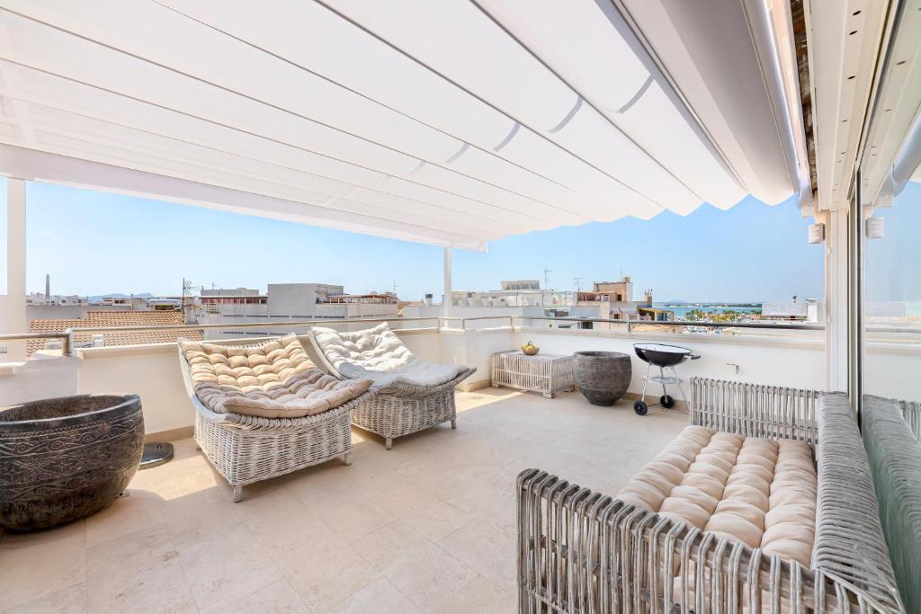 a patio with couches and chairs on a balcony at Casa Rewa in Port d'Alcudia