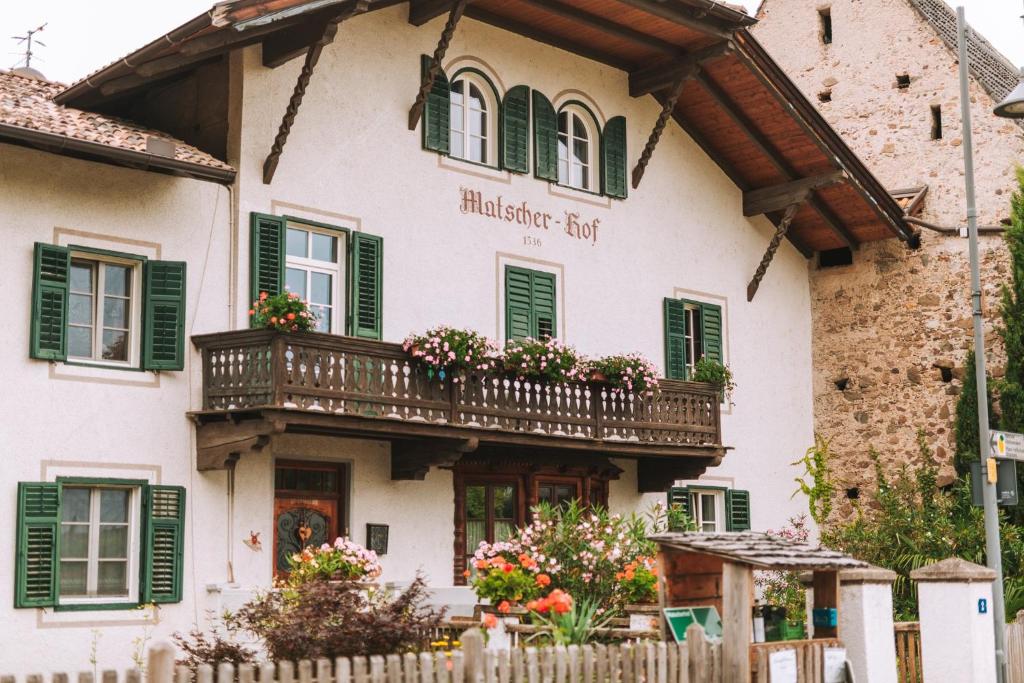a building with a balcony with flowers on it at Matscherhof Lana in Lana