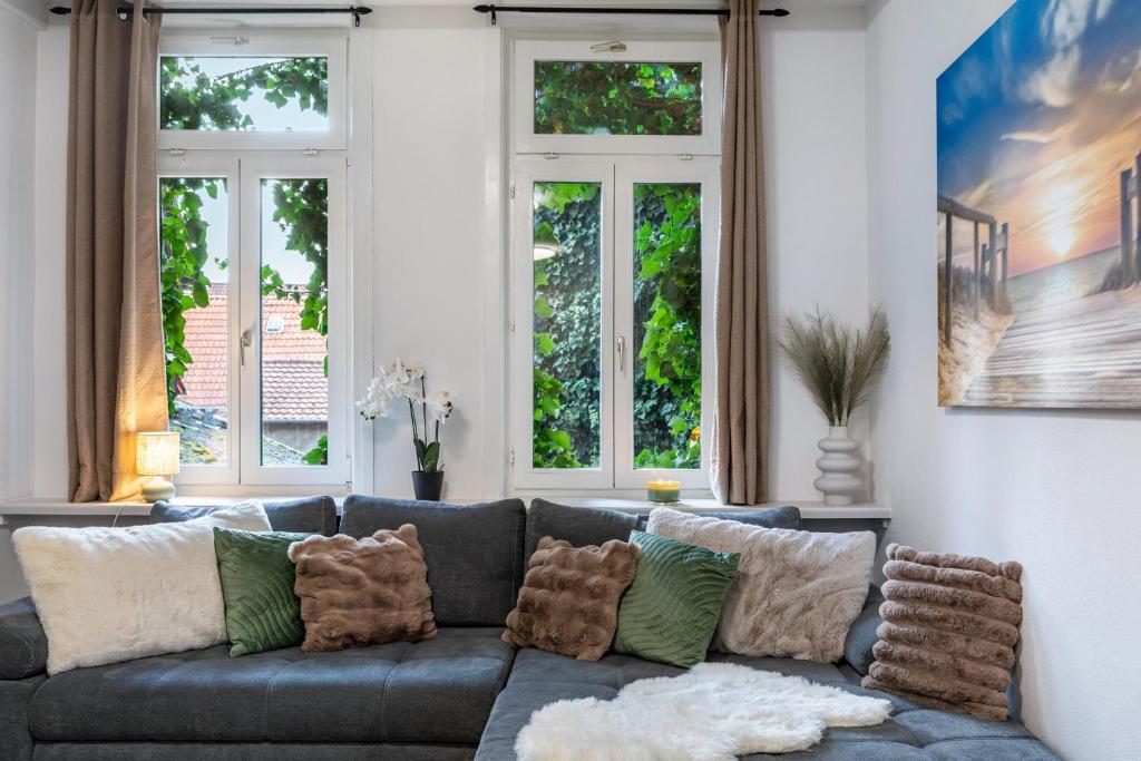 a living room with a gray couch with pillows at Marktplatz Ferienwohnung in Alsfeld