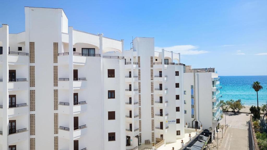 a white building with the ocean in the background at R2 Cala Millor in Cala Millor