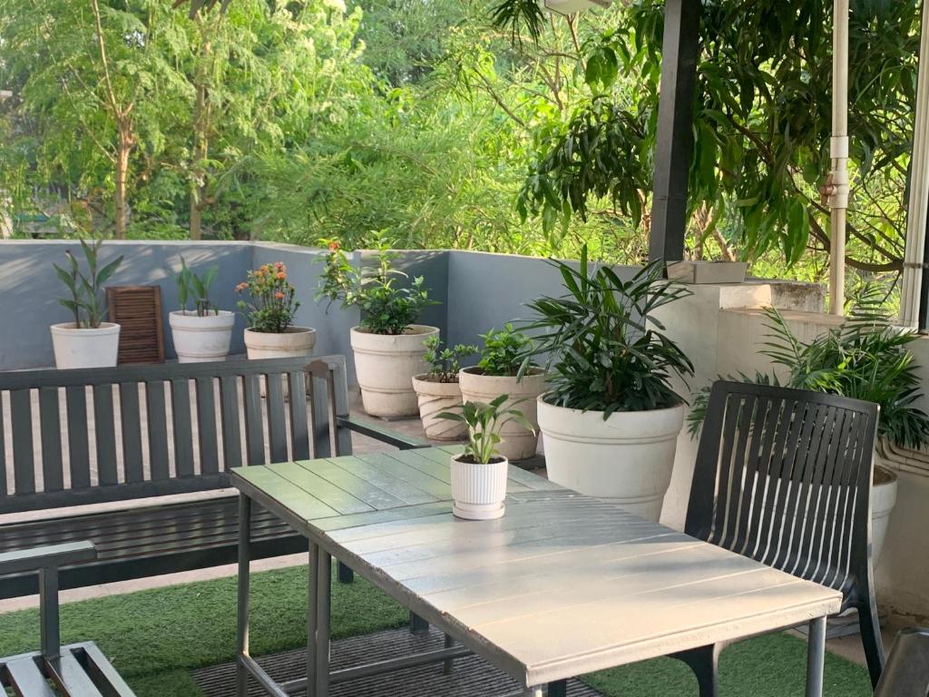 a table and chairs with potted plants on a patio at Home Away From Home in Kolhapur