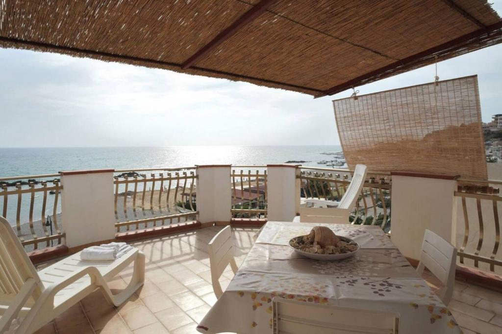 a balcony with a table and chairs and the ocean at Appartamento C - Le Terrazze in Ribera