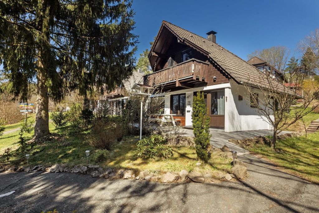 a house with a tree and a driveway at Ferienhaus Rotkäppchen in Frankenau