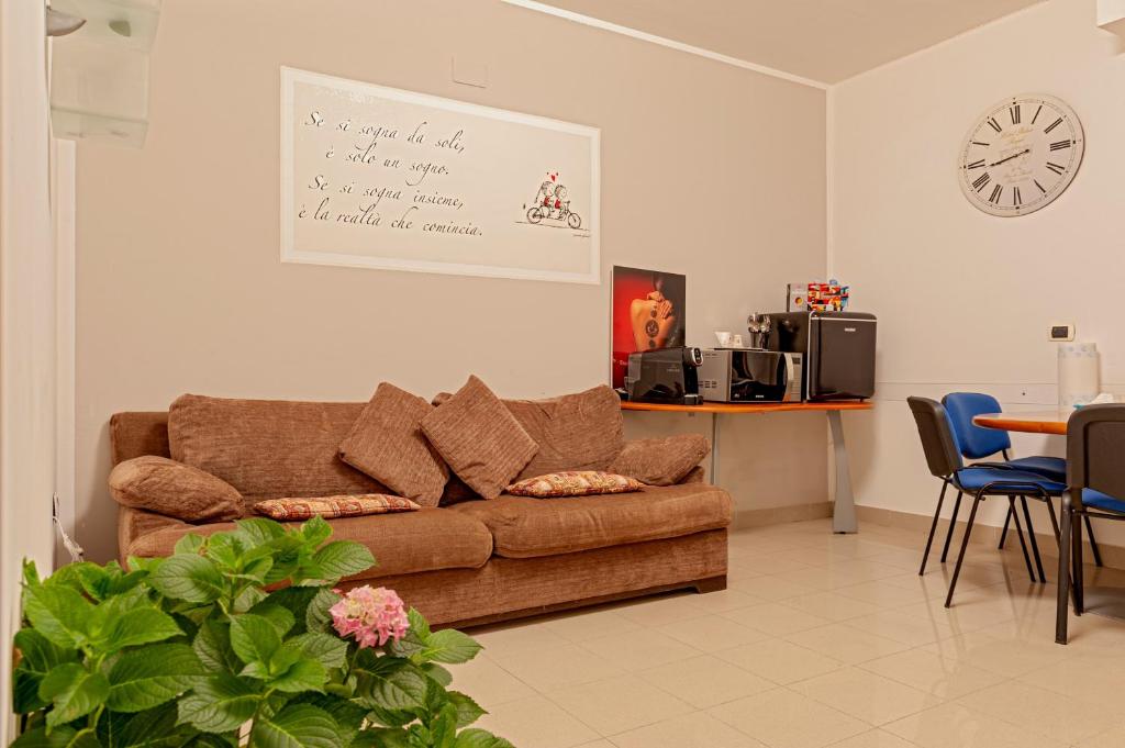 ein Wohnzimmer mit Sofa, Tisch und Uhr in der Unterkunft Valle Benedetta in Stagno