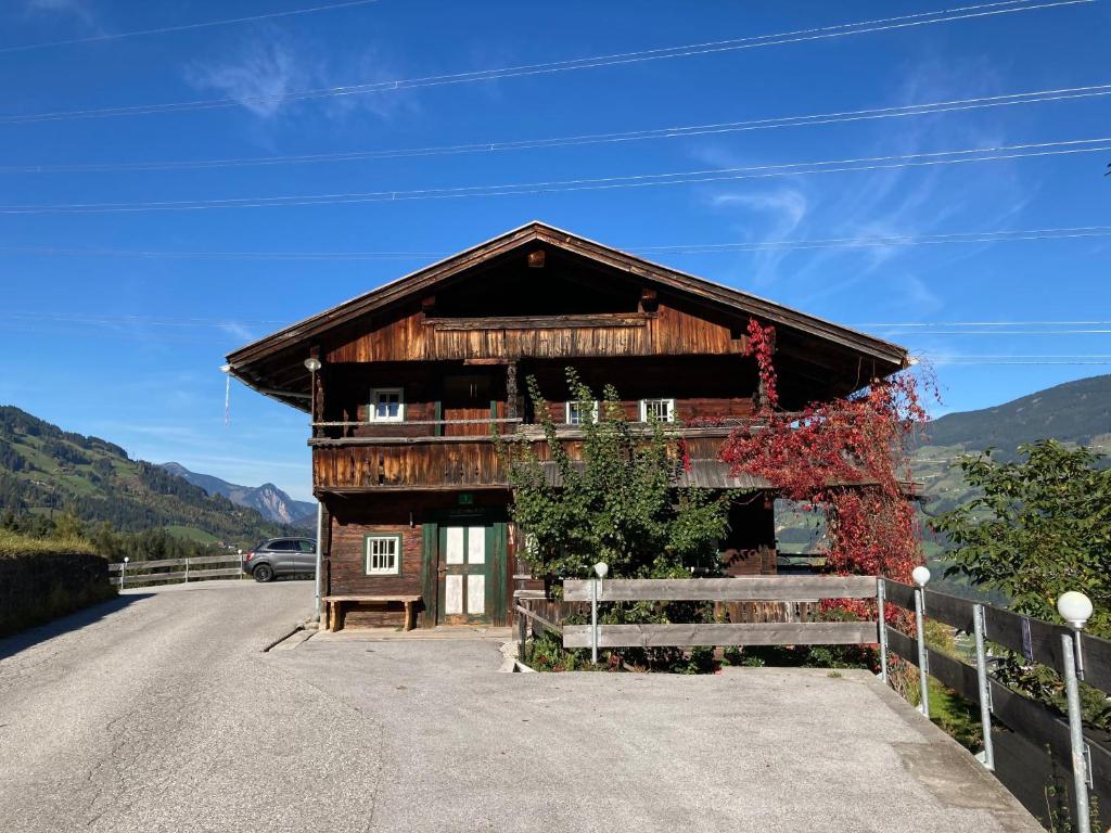a building on a road with a fence at Berghaus Wiesegg - Uriges Tiroler in Fügenberg