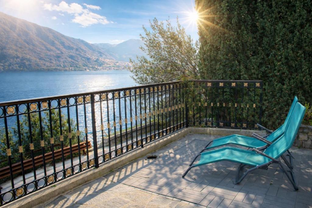 a blue chair sitting on a balcony overlooking a lake at Emilia's Lakeview Terrace in Brienno