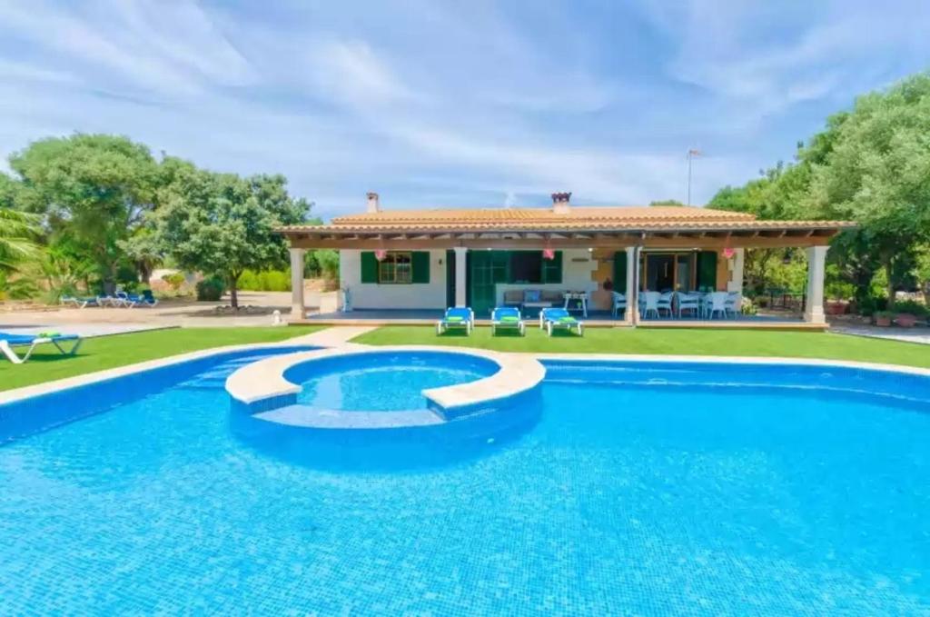 a villa with a swimming pool and a house at Sa Sargantana in Islas Baleares