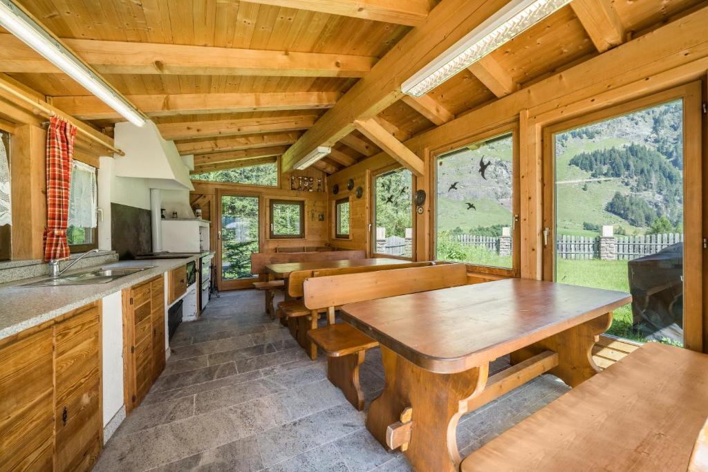 a kitchen and dining room with wooden ceilings and windows at Ferienhaus Maria Steinröserl in Moso
