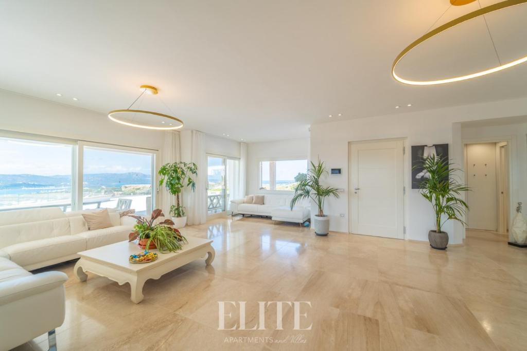 a living room with white furniture and large windows at Elite Collection Villa Noemi in Porto Rotondo