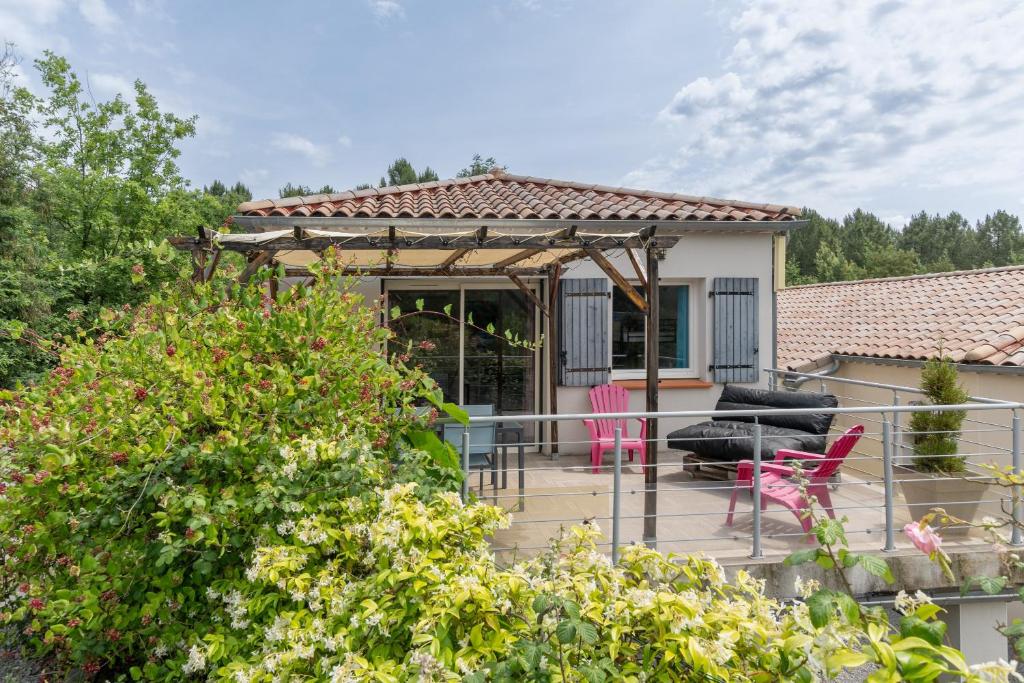 a house with a deck with pink chairs at Le Pequelet in Payzac